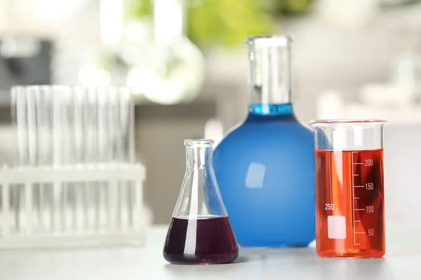 Verrerie avec liquides de couleur sur la table en laboratoire — Photo