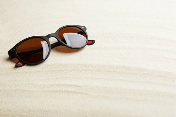 Stylowe okulary przeciwsłoneczne na białym piasku, miejsce na tekst. Czas letni — Zdjęcie stockowe