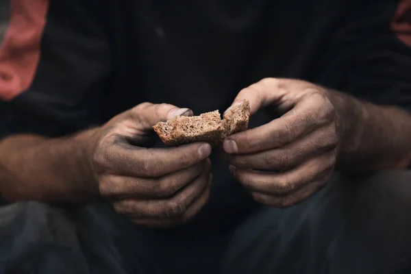 Poor homeless with piece of bread outdoors, closeup — Stock Photo, Image