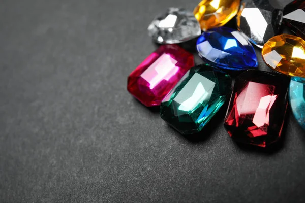 Pile of different beautiful gemstones on black background, closeup. Space for text — Stock Photo, Image