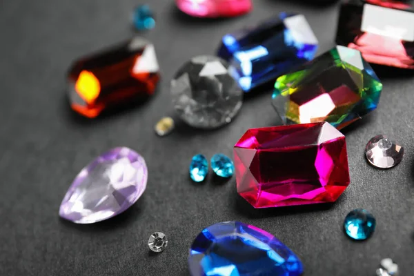 Different beautiful gemstones on black background, closeup — Stock Photo, Image