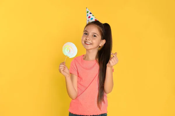 Szczęśliwa dziewczyna z cukierkami na żółtym tle. Święto urodzin — Zdjęcie stockowe