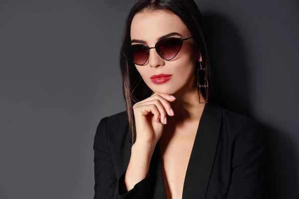 Piękna kobieta w kurtce i okularach na czarnym tle — Zdjęcie stockowe
