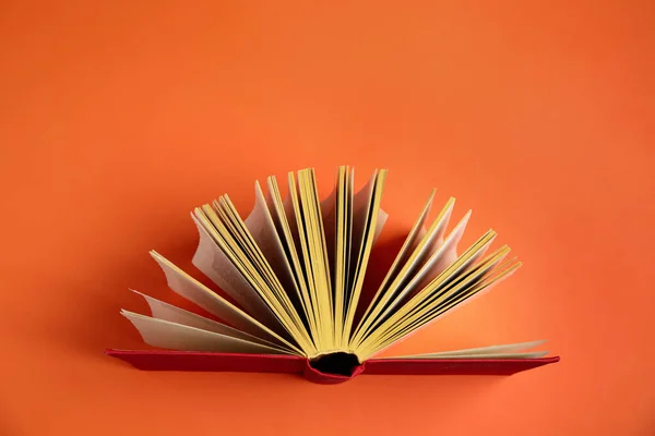 Livro de capa dura sobre fundo laranja, vista superior — Fotografia de Stock