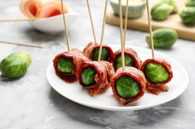 Brüksel lahanası ile kaplanmış gri masa üzerinde pastırma, yakın plan