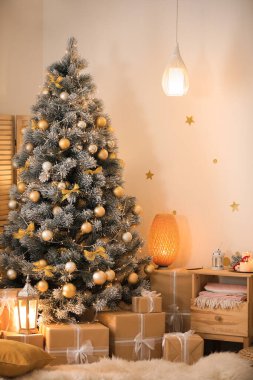 Güzel dekore edilmiş Noel ağacı ve şenlik odasının içinde hediye kutuları.