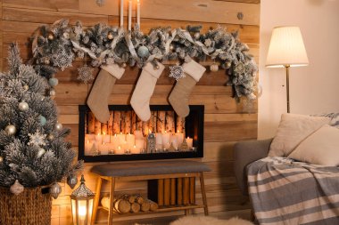 Dekoratif şömineli ve Noel çoraplı şenlik odası.