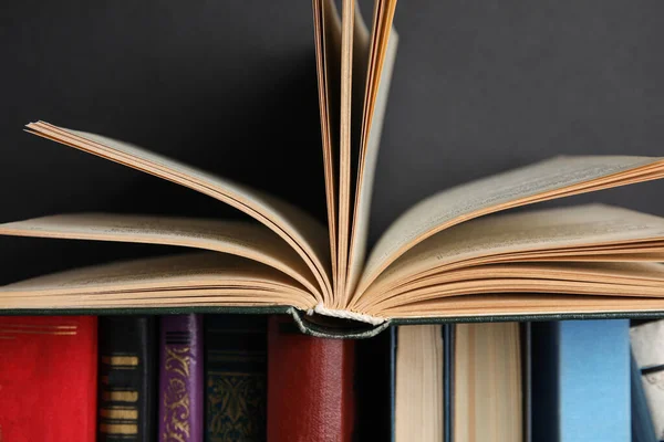 Verschillende hardcover boeken tegen zwarte achtergrond, close-up — Stockfoto