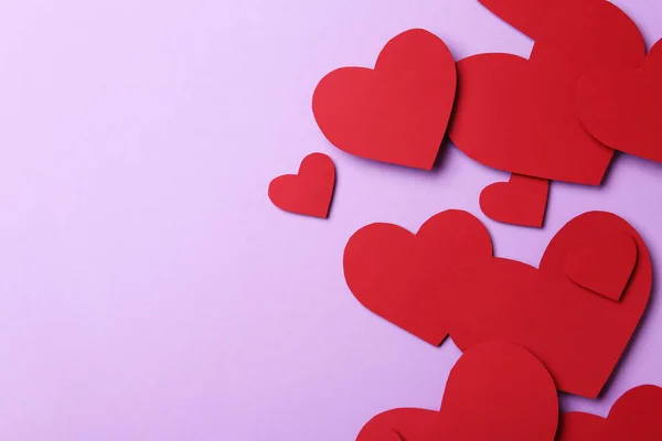 Κόκκινες χάρτινες καρδιές σε βιολετί φόντο, επίπεδη lay. Χώρος για κείμενο — Φωτογραφία Αρχείου