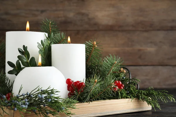 Hermosa composición navideña con velas blancas ardientes sobre fondo de madera — Foto de Stock