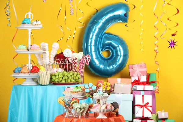 Mesa de postres en habitación decorada con globo azul para fiesta de cumpleaños de 6 años — Foto de Stock