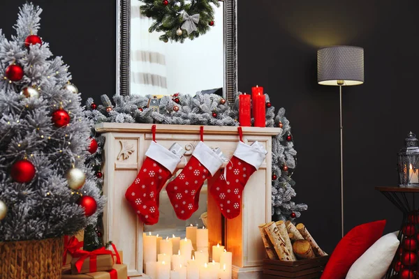 Камин с рождественскими чулками в праздничном интерьере комнаты — стоковое фото