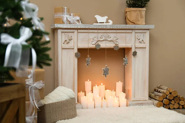 Kominek z płonącymi świecami we wnętrzu świątecznego pokoju. Święta Bożego Narodzenia — Zdjęcie stockowe