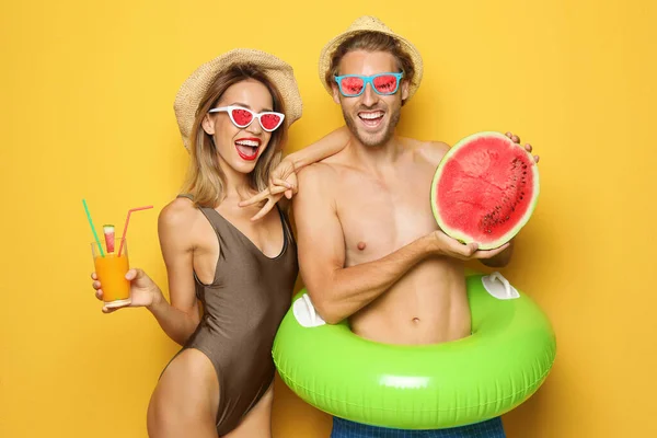 Feliz pareja joven en ropa de playa sobre fondo rosa. Gafas de sol de frutas como tendencia de verano — Foto de Stock