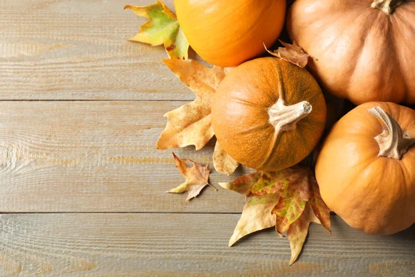 Ripe pumpkins on wooden background, flat lay with space for text. Holiday decoration — Stock Photo, Image