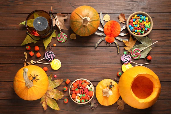 Flat lay composition with pumpkin head Jack lantern and Halloween treats on wooden background. Space for text — Stock Photo, Image