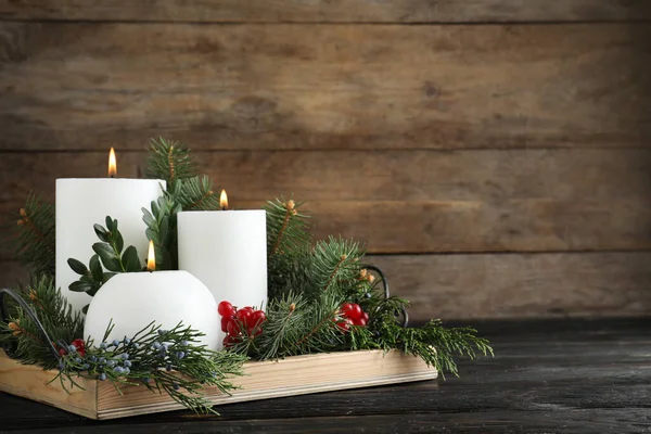 Hermosa composición navideña con velas blancas encendidas sobre fondo de madera. Espacio para texto — Foto de Stock