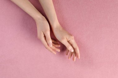 Pembe kumaşta güzel elleri olan bir kadın.