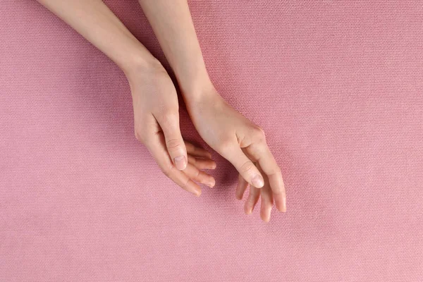 분홍색 직물 위에 아름다운 손을 얹은 여인, 맨 위에 보이는 것 — 스톡 사진