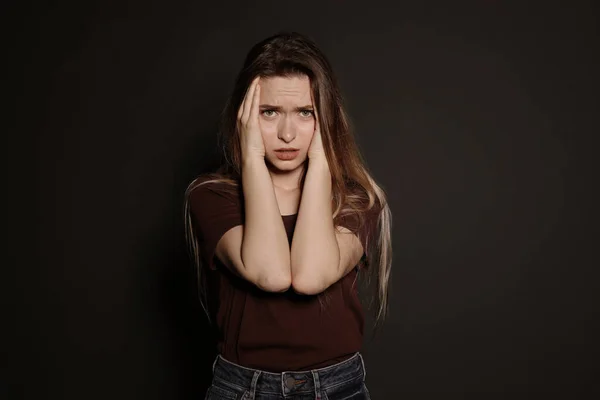 Retrato de mujer joven molesta sobre fondo oscuro — Foto de Stock