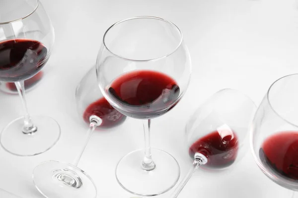 Bicchieri trasparenti con squisito vino rosso su sfondo bianco — Foto Stock