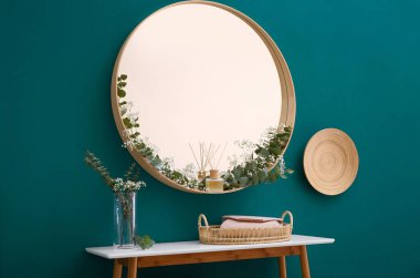 Yuvarlak ayna ve modern oda iç yeşil duvara yakın aksesuarları ile masa