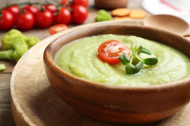Tahta tepside servis edilen domatesli ve mikro yeşillikli brokoli kremalı çorba.