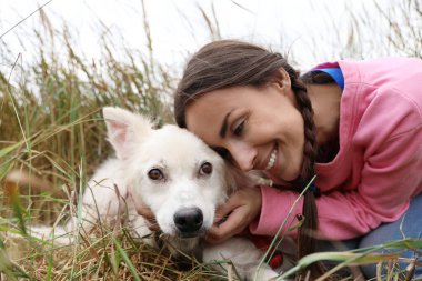 Hayvan barınağında evsiz köpekle birlikte gönüllü bir kadın.