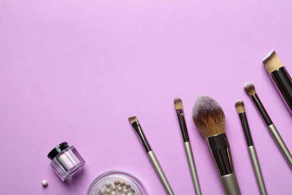 Vlakke lay compositie met make-up borstels op lila achtergrond. Ruimte voor tekst — Stockfoto