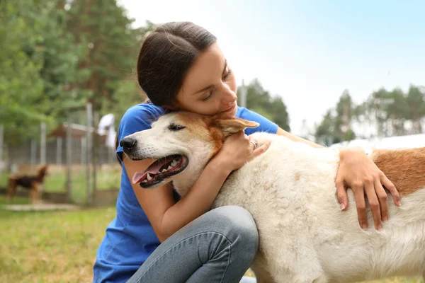 Mujer voluntaria con perro sin hogar en refugio de animales al aire libre — Foto de Stock