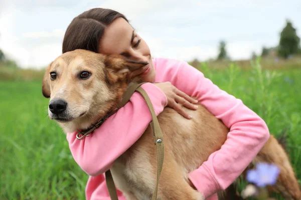 Mujer voluntaria con perro sin hogar en refugio de animales al aire libre — Foto de Stock