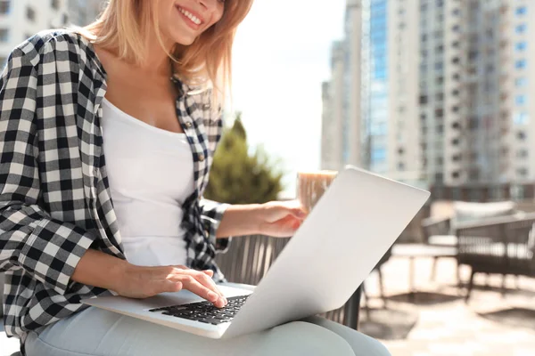 Donna che utilizza il computer portatile al caffè all'aperto, primo piano — Foto Stock