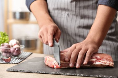 Adam mutfakta masada taze çiğ et kesme, closeup