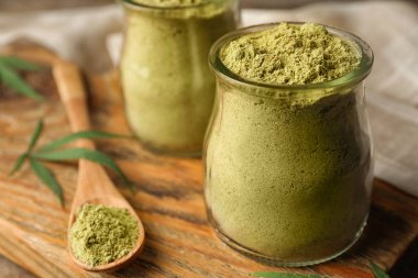 Tahta üzerinde kenevir protein tozu kavanozları, yakın plan. Metin için boşluk