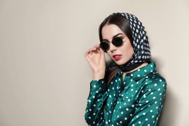 Bej arka planda şık güneş gözlüklü güzel bir kadın. Metin için boşluk