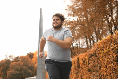 Parkta koşan şişman genç bir adam. Fitness yaşam tarzı