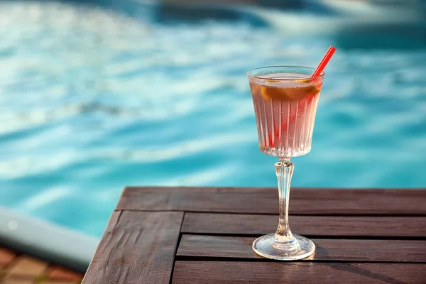 Copo de coquetel de verão fresco na mesa de madeira perto da piscina ao ar livre. Espaço para texto — Fotografia de Stock