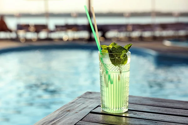 Verre de cocktail frais d'été sur table en bois près de la piscine extérieure. Espace pour le texte — Photo