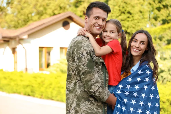 Άντρας με στρατιωτική στολή και η οικογένειά του με αμερικανική σημαία σε εξωτερικούς χώρους — Φωτογραφία Αρχείου