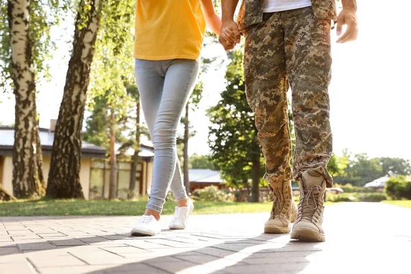 身穿军服的男人和他的女朋友在阳光灿烂的公园散步，特写镜头 — 图库照片