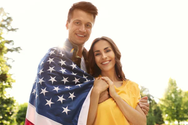 Hombre en uniforme militar con bandera americana y su esposa en Sunny Park —  Fotos de Stock
