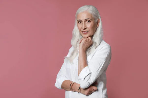 Retrato de bela mulher madura no fundo rosa, espaço para texto — Fotografia de Stock