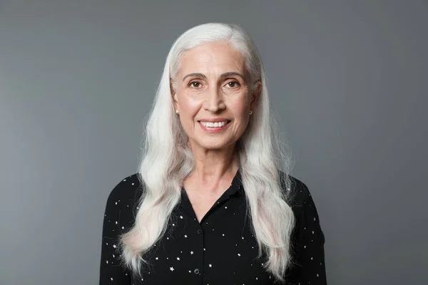 Porträtt av vacker mogen kvinna på grå bakgrund — Stockfoto