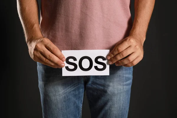 Ο άνθρωπος που κρατά το SOS να υπογράφει σε μαύρο φόντο, κοντινό. Ουνολογικά προβλήματα — Φωτογραφία Αρχείου