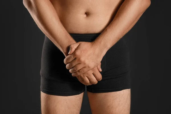 Mann mit Schmerzen auf schwarzem Hintergrund, Nahaufnahme. Probleme mit der Urologie — Stockfoto