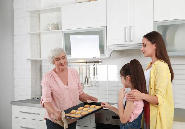 Feliz avó ajudando sua família a assar biscoitos na cozinha — Fotografia de Stock