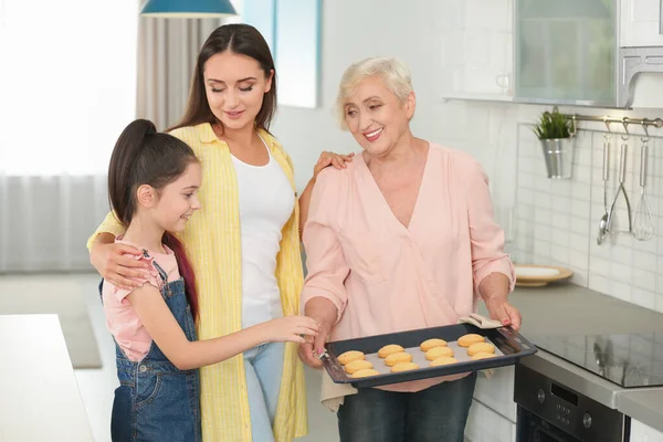 Ευτυχισμένη γιαγιά βοηθώντας την οικογένειά της να ψήνουν μπισκότα στην κουζίνα — Φωτογραφία Αρχείου