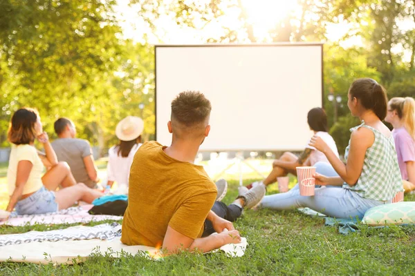Young people watching movie in open air cinema. Space for text — Stock Photo, Image
