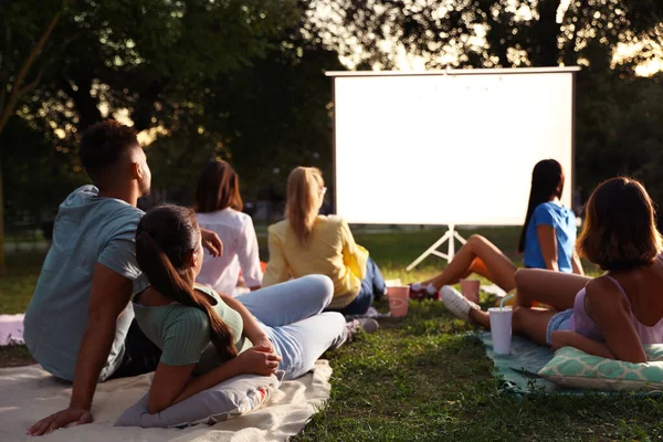 Młodzi ludzie oglądają film w kinie na otwartym powietrzu. Miejsce na tekst — Zdjęcie stockowe