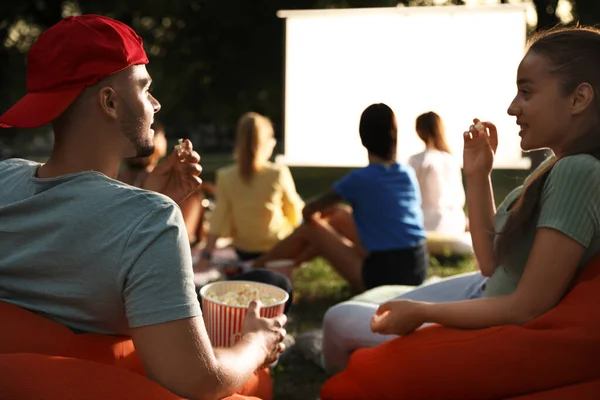 Młoda para z popcorn oglądania filmu w kinie na otwartym powietrzu. Miejsce na tekst — Zdjęcie stockowe